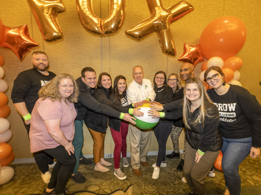 Celebration at Annual Growth Summit, have team group photo all hands on the beach volleyball.