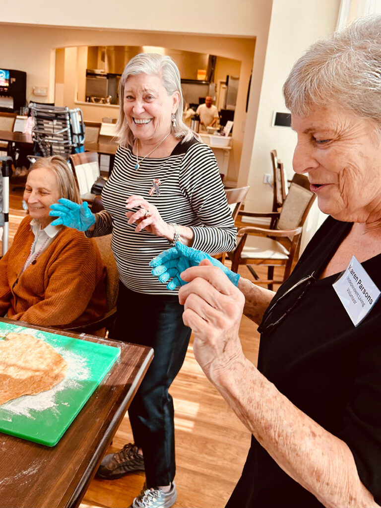 Community members baking together in senior living neighborhood.