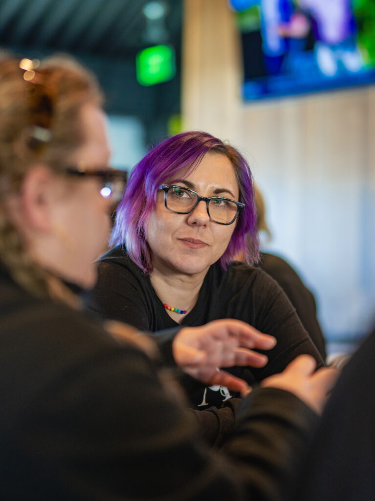 A senior member of Arrow Senior Living's marketing team listens in conversation at the 2025 sales summit.