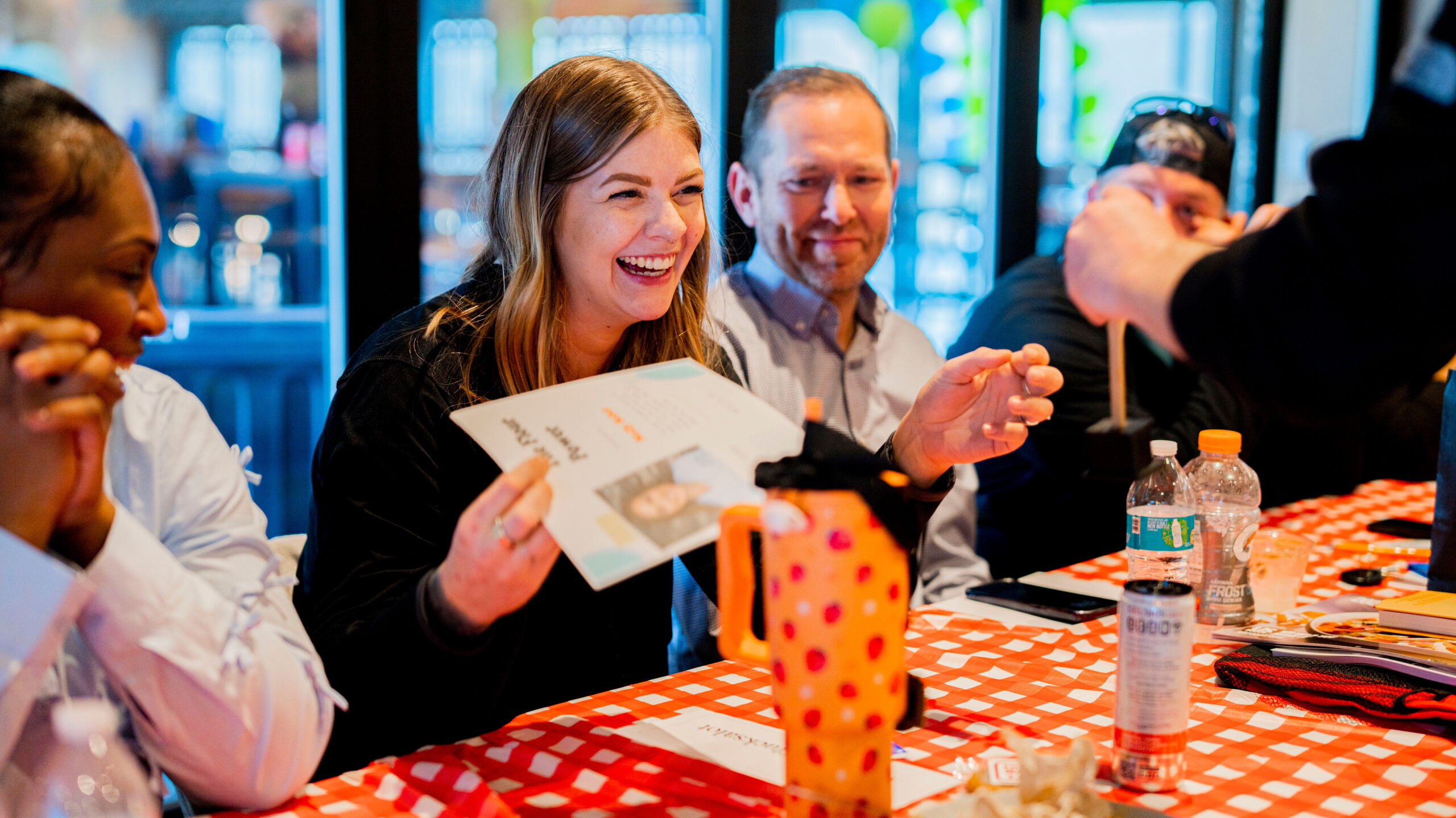 Arrow Senior Living culinary directors smile at a table together during a gathering at the 2025 Culinary summit.