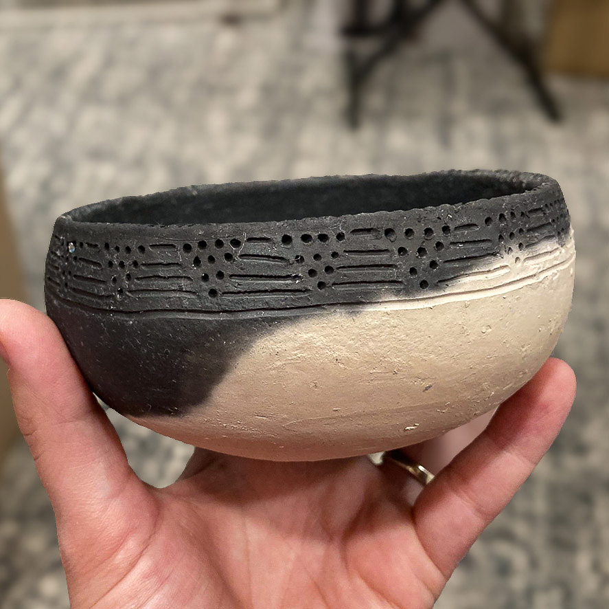 Pit-fired clay bowl created by Reuben IronHorse-Kent for Arrow Senior Living, highlighting carved dot-and-line patterns inspired by Oneota cultural pottery traditions.