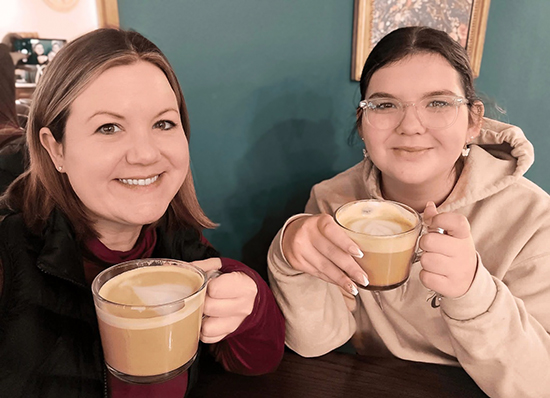 Two women enjoy a cappuccino at a local business.