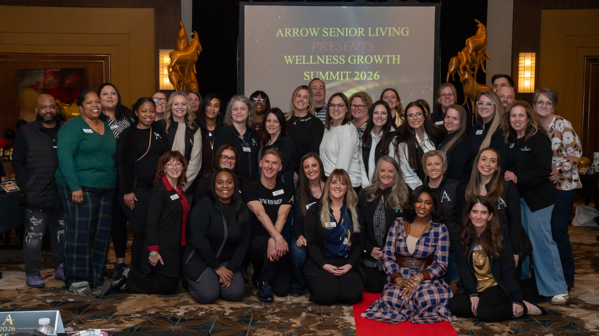 Group of Arrow Senior Living team members smiling together at the Wellness Growth Summit 2026.