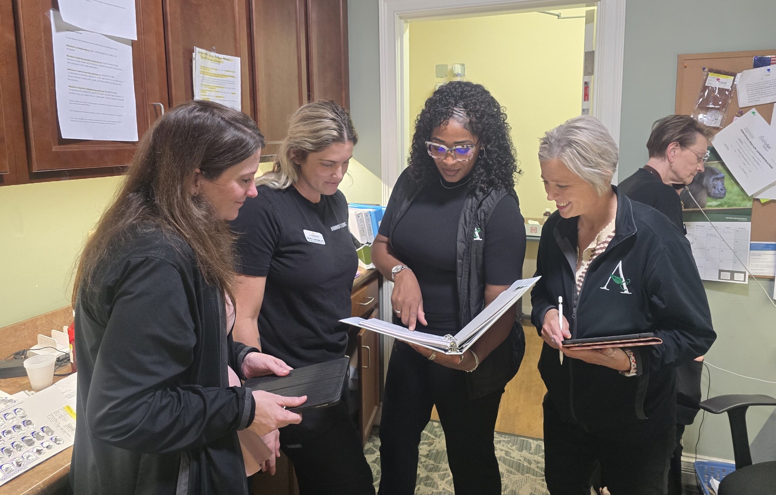 Arrow Senior Living team members review materials together during a community wellness visit.